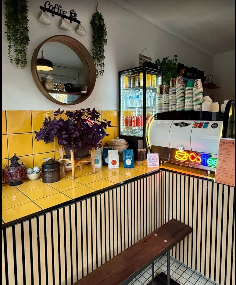 Postie's yellow tiled counter with the coffee machine and grinder behind it